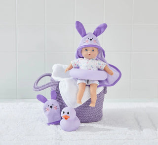 Doll in a purple bunny outfit with plush toys in a basket on a tiled floor.