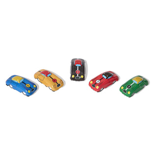 Five small toy race cars in different colors are arranged on a plain white background. The cars are blue, tan, black, red, and green, each with simple painted details like headlights, wheels, and racing decals.