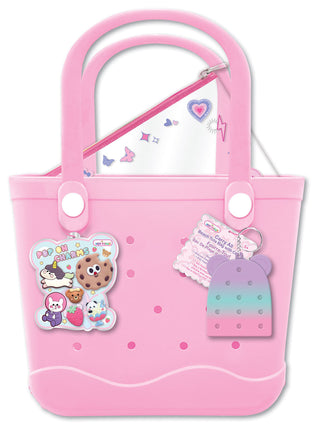 Pink tote bag with cartoon character stickers and a heart design on a white background