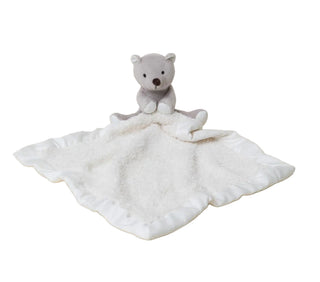 Tan teddy bear with a matching blanket on a light beige background
