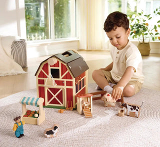 Hape barn toy with farmer figure and reversible boards