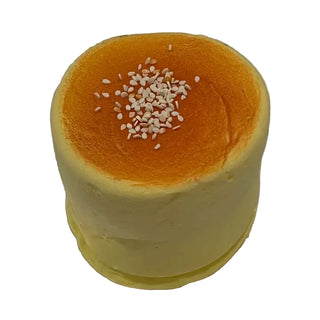 Yellow cake with a browned top layer on a white background